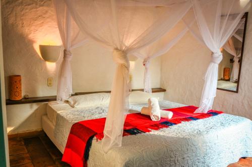 a bedroom with a bed with a teddy bear on it at Hotel Spa El Cogollo By MH in Barichara