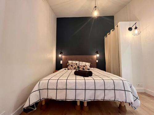 1 dormitorio con 1 cama con pared negra en Suite Coraline en Lyon