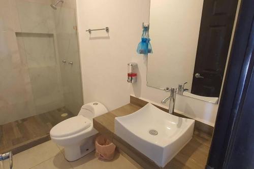 a bathroom with a white toilet and a sink at Departamento a 5 minutos de la playa!! in Mazatlán