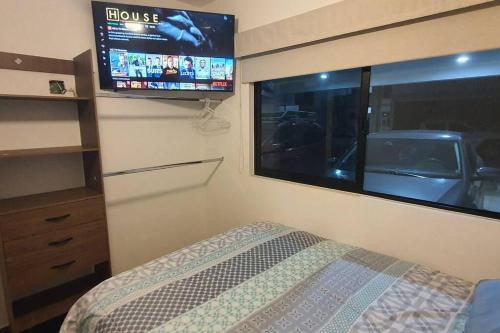 a bedroom with a bed and a flat screen tv at Departamento a 5 minutos de la playa!! in Mazatlán