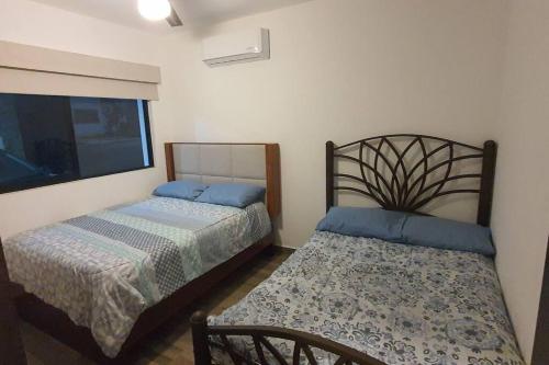 a bedroom with two beds and a window at Departamento a 5 minutos de la playa!! in Mazatlán