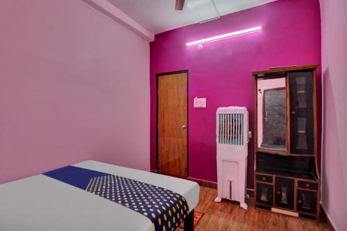 um quarto com duas camas e uma parede roxa em SPOT ON Hotel BRC Inn em Nagpur