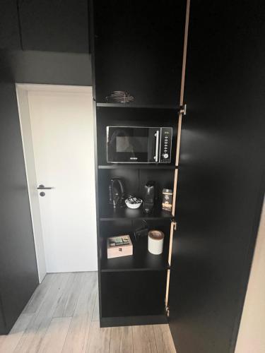a kitchen with a black cabinet with a microwave at Haus am Waldrand in Bad Hersfeld