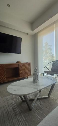 a living room with a coffee table and a chair at Amazing 2 bedroom condo in Golden Zone steps away from the ocean in Bucerías