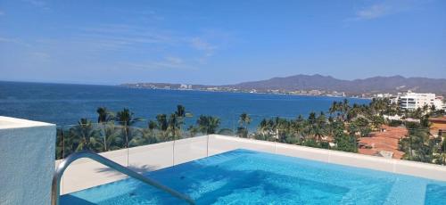 a swimming pool with a view of the ocean at Amazing 2 bedroom condo in Golden Zone steps away from the ocean in Bucerías
