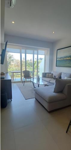 a living room with a couch and a table at Amazing 2 bedroom condo in Golden Zone steps away from the ocean in Bucerías