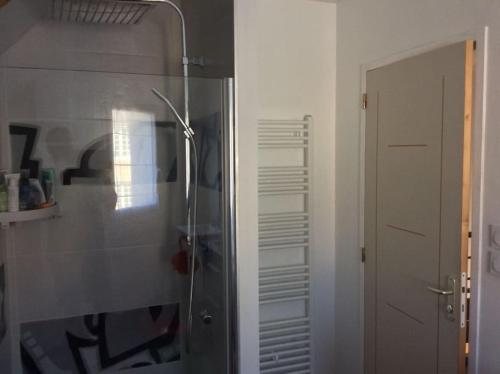 La salle de bains est pourvue d'une douche avec une porte en verre. dans l'établissement Plages débarquements .DDay. Près de Caen, à Verson