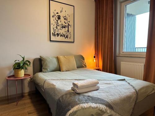 a bedroom with a bed with a plant on it at Momo Apartamenty Kręta in Wrocław