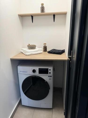 une cuisine avec un four micro-ondes sous un comptoir et une table dans l'établissement Souplex avec Jardin, à Sedan