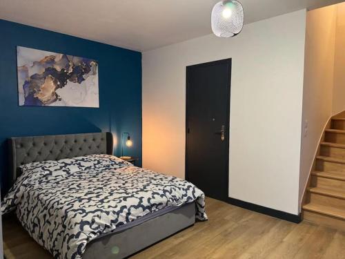 une chambre avec un lit et un mur bleu dans l'établissement Souplex avec Jardin, à Sedan