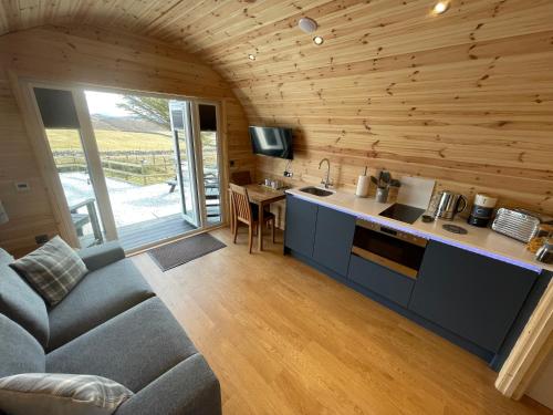 a kitchen and living room with a couch and a table at Stoer Pods - Suilven Pod in Lochinver
