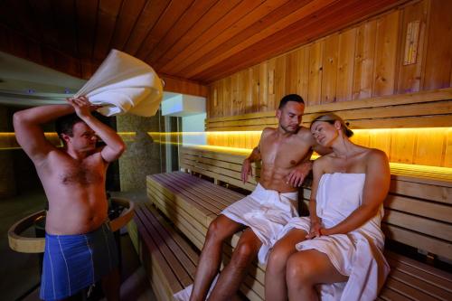 a man and a woman sitting in a sauna at Spa hotel Lanterna in Velké Karlovice