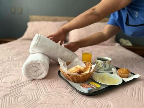 un vassoio per la colazione con un asciugamano e un cesto di cibo di Hotel Vitali a Concepción