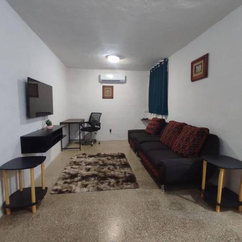 uma sala de estar com um sofá e uma televisão de ecrã plano em Depto Completo Villahermosa em Ocuilzapotlan