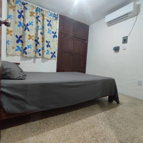 um quarto com uma cama, uma ventoinha e uma janela em Depto Completo Villahermosa em Ocuilzapotlan