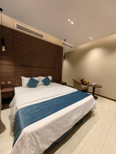 a bedroom with a large white bed with blue pillows at Ranahouse in Jeddah
