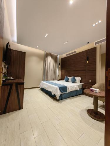 a large bedroom with a bed and a table at Ranahouse in Jeddah