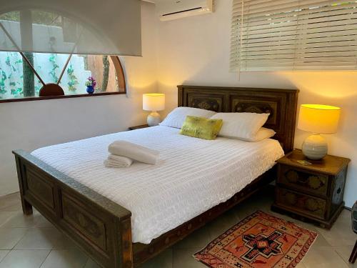 a bedroom with a bed with two lamps and a window at Beach Bliss - Tropical tranquility, 3 mins walk to beach in Suffolk Park