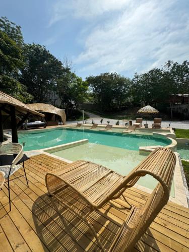 uma piscina com duas cadeiras e um deque com em Akasha suites em Doradal