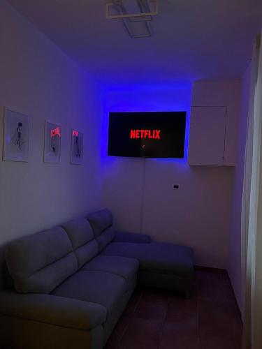 ein Wohnzimmer mit einem Sofa und einem TV mit dem Netflix-Schild in der Unterkunft Appartamento vicino al centro di Tortona in Tortona
