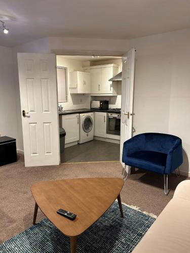 a living room with a table and a blue chair at Cosy 2 Bedroom Apartment with Parking by Cloud Suites in Manchester