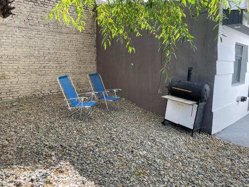 2 sillas y estufa en un patio en Hermoso departamento con patio en Rio Gallegos en Río Gallegos