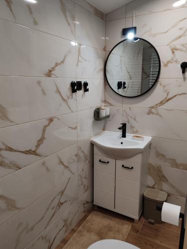 a bathroom with a sink and a mirror at Apartman Orchid in Plitvička Jezera