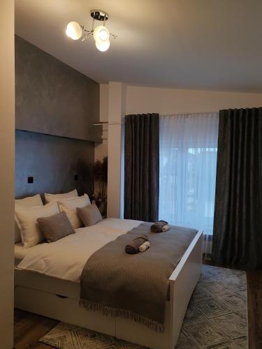 a bedroom with a large bed with two slippers on it at Apartman Orchid in Plitvička Jezera