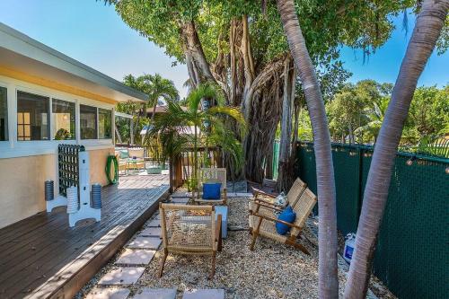 a patio with palm trees and chairs on a house at Paradise Palms - Movie Theater - Hot Tub - Pool - Arcade - Boat & RV Parking in Marathon