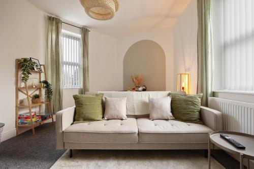 a living room with a white couch with green pillows at Luxury Sheffield Apartment - Your Ideal Home Away From Home in Stannington