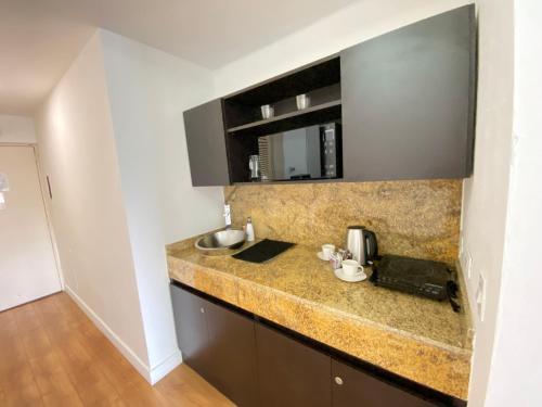 a kitchen counter with a sink and a mirror at Suite. HotelCCT in Caracas