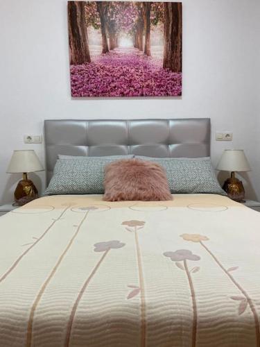 a bedroom with a bed with a painting on the wall at Punta Prima Gataway in Torrevieja