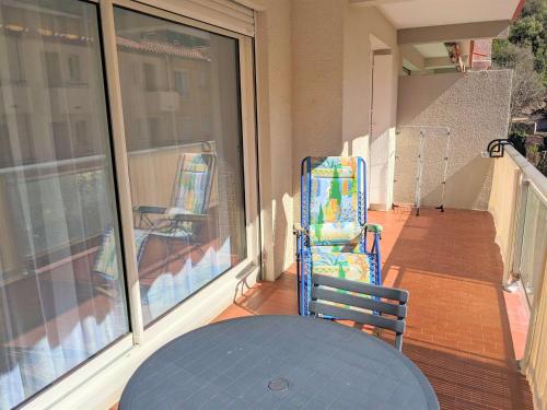 einen Balkon mit 2 Stühlen und einem Tisch auf einer Veranda in der Unterkunft NOUVEAU Appartement T2 meublé classé, secteur petite Provence in Amélie-les-Bains-Palalda