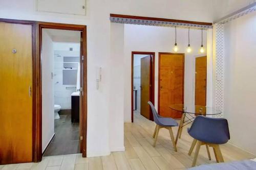a dining room with a table and a blue chair at En el corazón de la ciudad! in Buenos Aires