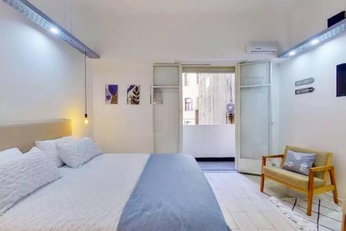 1 dormitorio con 1 cama blanca grande y 1 silla en En el corazón de la ciudad! en Buenos Aires