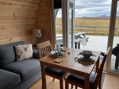 a dining room with a table and a couch at Stoer Pods - Quinag Pod in Lochinver