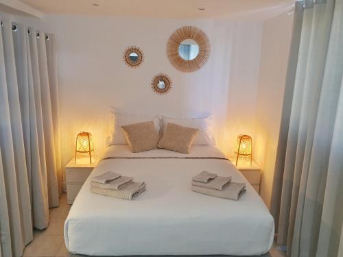 une chambre avec un lit blanc avec deux serviettes dessus dans l'établissement Studio Cosy & Lumineux *Centre ville Cannes*, à Cannes