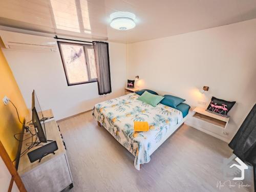 Schlafzimmer mit einem Bett und einem Flachbild-TV in der Unterkunft Airport Pamatai Studio in Faaa