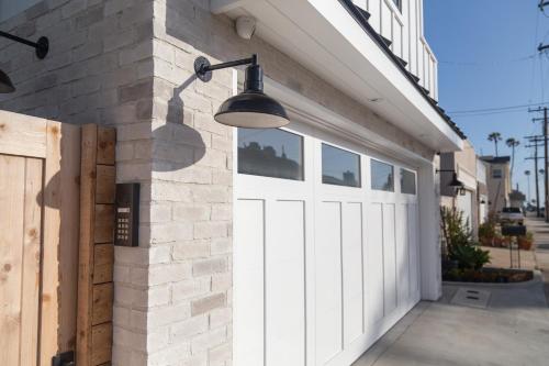 a garage with a white garage door and a light at Newport Surf Casita in Newport Beach