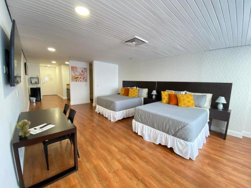 una camera d'albergo con 2 letti e una scrivania di Suite. HotelCCT a Caracas