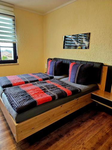 a bed with a wooden frame in a room at Villa Harzblick in Ballenstedt