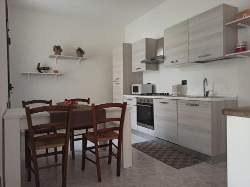 a kitchen with a table and chairs in a kitchen at Casa Adele in San Sperate