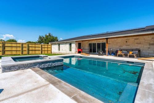 a swimming pool in the backyard of a house at The Gateway - 6BED W Two Houses GameRoom & Pool in Cedar Park