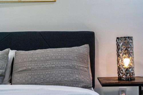 a bed with a pillow and a lamp on a table at The Gateway - 6BED W Two Houses GameRoom & Pool in Cedar Park