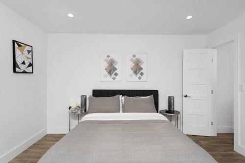 a bedroom with a large bed with white walls at The Gateway - 6BED W Two Houses GameRoom & Pool in Cedar Park