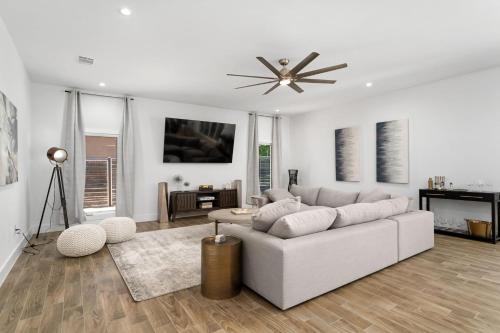 a living room with a white couch and a ceiling fan at The Gateway - 6BED W Two Houses GameRoom & Pool in Cedar Park
