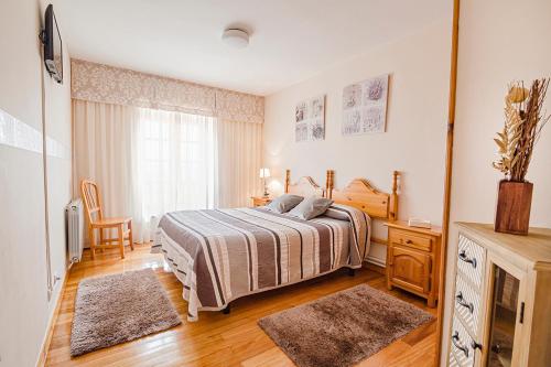 een slaapkamer met een bed, een bureau en een raam bij Posada la Hijuela in Queveda