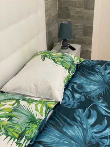 a bed with a pillow and a lamp on a table at Blue Iris Home Sanremo in Sanremo