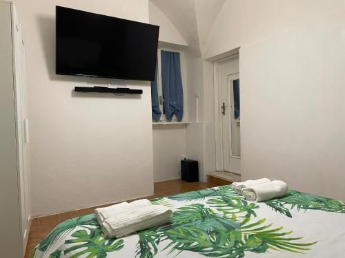 a bedroom with a bed with a flat screen tv on the wall at Blue Iris Home in Sanremo