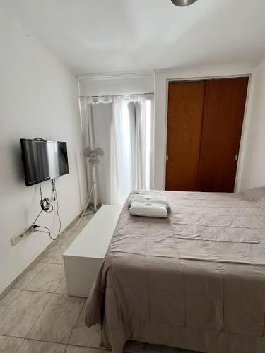 um quarto com uma cama e uma televisão na parede em Departamento Luminoso en Nueva Cordoba em Córdoba